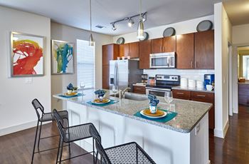 A kitchen with a white counter top and a black chair.at Century Cedar Hill, Texas